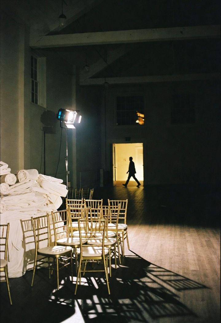 Empty hall after an event with stacked chairs and a work light